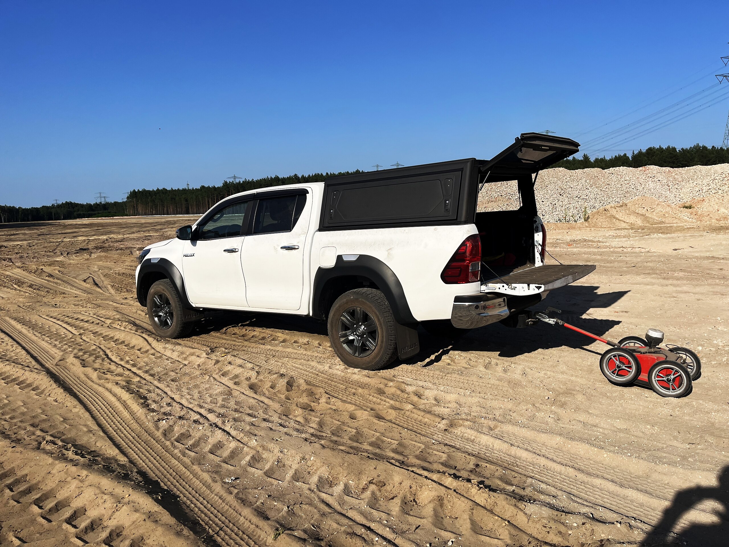 Pickup mit Bodenradar-Messwagen auf sandigem Gelände für die Leitungsortung.
